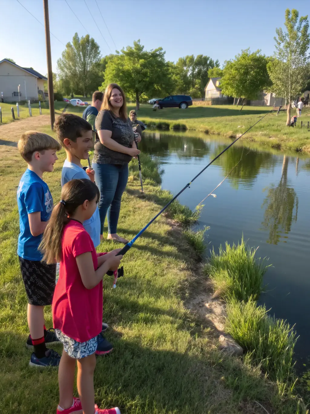 A serene image of families fishing at a communal pond managed by ASSOCIATION TOURBIERES ET LOISIRS, showcasing the joy of outdoor recreation and community engagement.